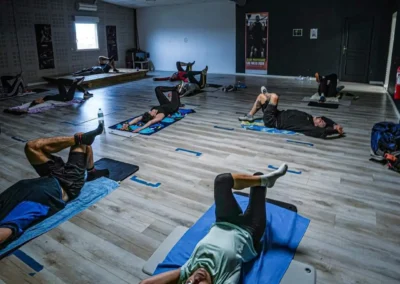 Participants réalisant des exercices de gainage et de renforcement abdominal lors d'un cours Abdos Étirements Fitaccess