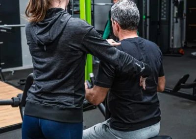 Coach accompagnant un adhérent lors d'un bilan corporel et du suivi de ses objectifs sportifs