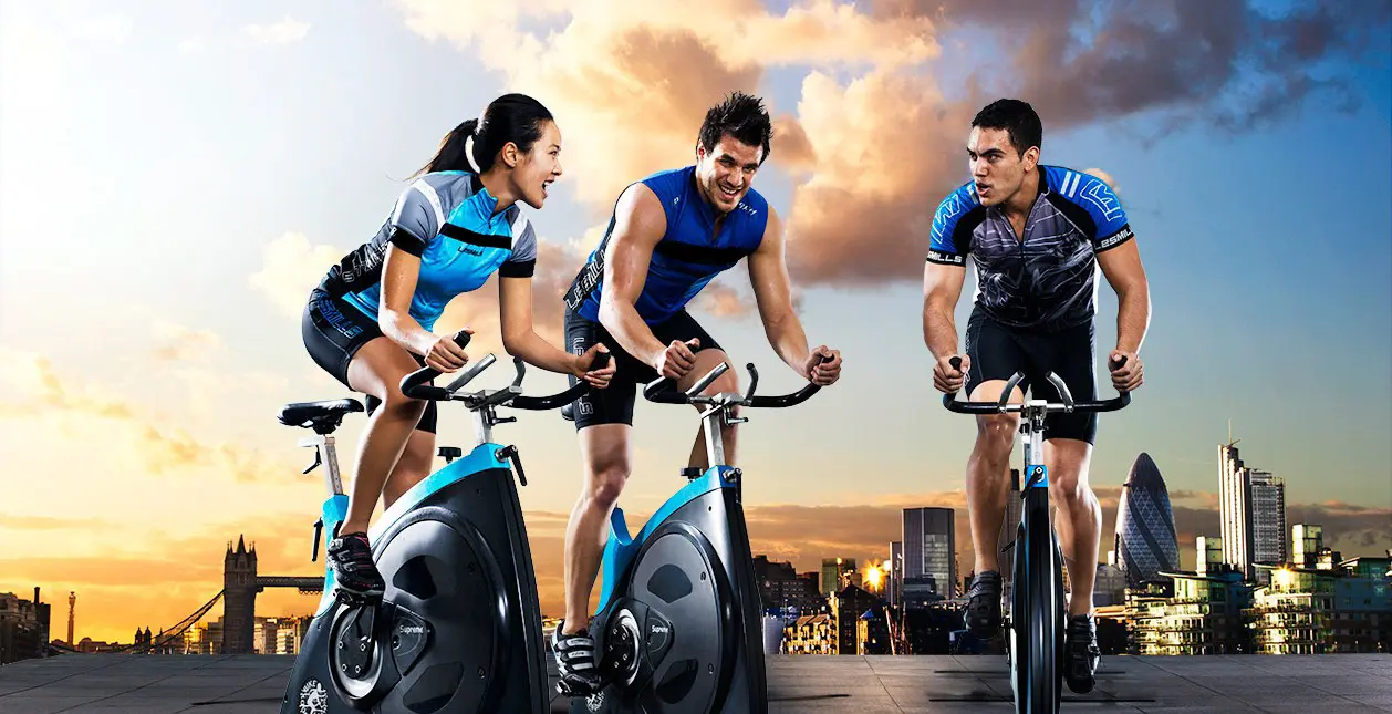 Participants à un cours RPM de vélo indoor encadré dans un club Fitaccess