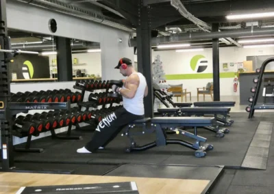 Adhérent réalisant un exercice avec haltères dans l’espace musculation libre Fitaccess