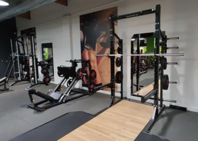 Espace musculation libre du club Fitaccess Tullins avec rack à squat, bancs et poids libres.