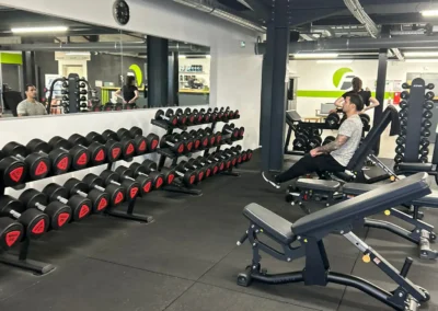 Vue générale de l’espace musculation libre avec bancs et haltères chez Fitaccess